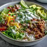 Spicy turkey taco bowl topped with diced avocado, shredded cheese, and fresh cilantro, ready to serve.