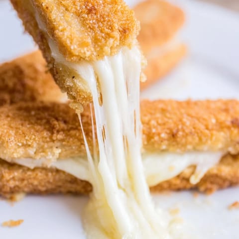 Crispy mozzarella sticks stuffed inside a golden, melty grilled cheese sandwich served with marinara.