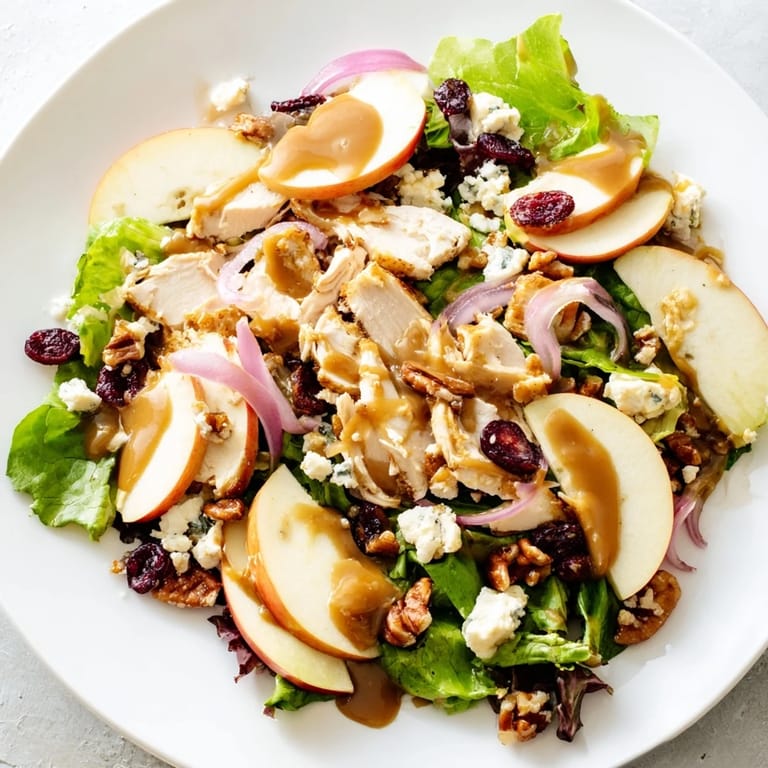 A rustic serving platter holds the beautiful Caramel Apple Chicken Salad, paired with a glass of crisp white wine.