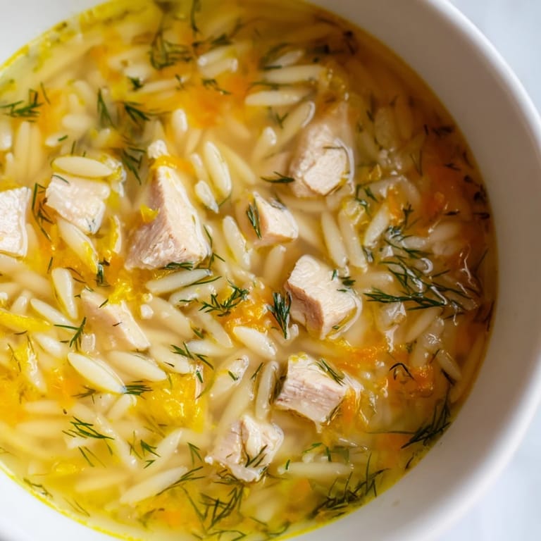 Homemade Chicken Lemon Orzo Soup featuring orzo pasta, shredded chicken, and vibrant veggies in a savory broth.