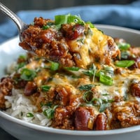 Warm Chili Bowl Base topped with creamy avocado and shredded cheddar over fluffy white rice.